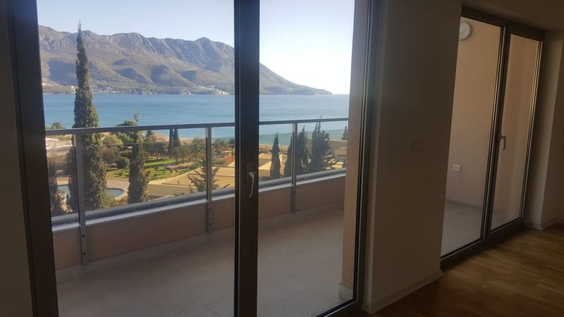 View from the living room of an apartment in Bečići, Montenegro: panoramic windows, a terrace with a view of the sea and mountains.