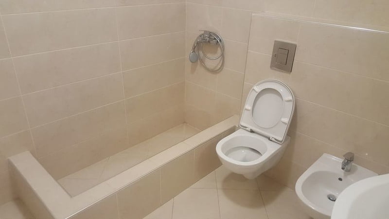 Modern bathroom in an apartment in Bečići, Montenegro: beige tiles, wall-mounted toilet, bidet, and shower area.