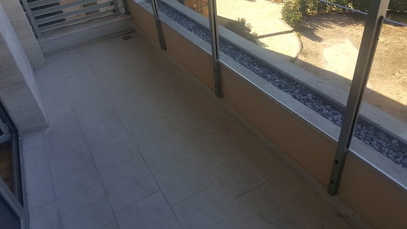 Spacious balcony with stone finishes and glass railing in a modern apartment, Bečići, Montenegro.
