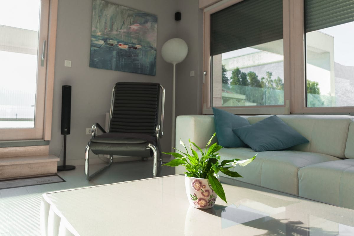 Modern living room in an apartment in Ljuta, Montenegro: leather sofa, armchair, panoramic windows, and stylish interior.
