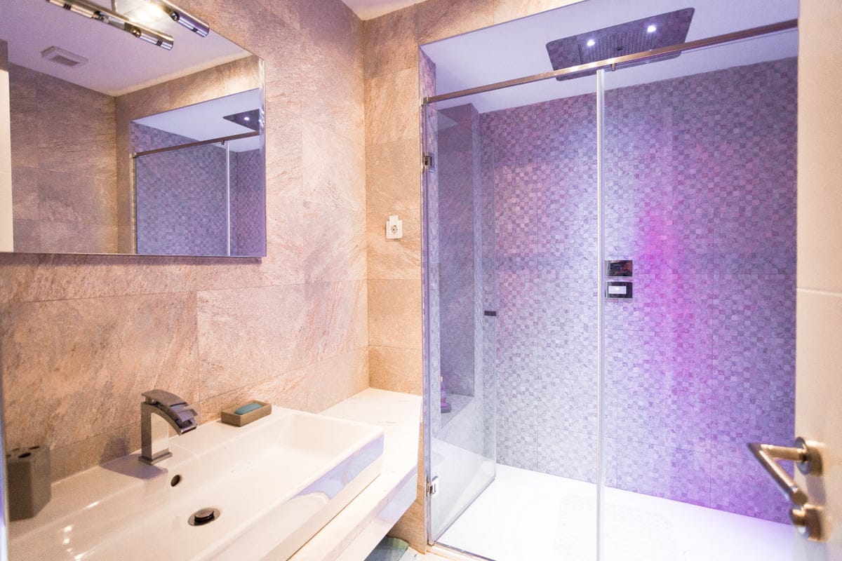 Modern bathroom with a shower cabin and lighting in an apartment, Ljuta, Montenegro. High-quality tile finish.