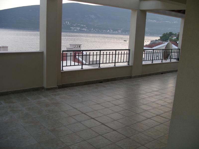 Spacious terrace with sea view in an apartment, Herceg Novi, Montenegro: tiled floor and wrought-iron railing.