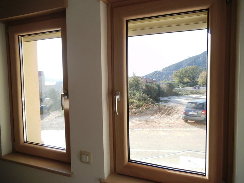 View from the living room window of the mountains and the street in the apartment, Becici, Montenegro: modern wooden double-glazed windows.