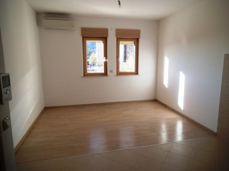 Bright living room with laminate flooring and air conditioning in an apartment in Bečići, Montenegro, mountain view from the windows.