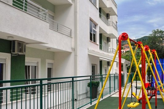 Modern residential complex with a playground and terraces in Herceg Novi, Montenegro. View of the building facade.