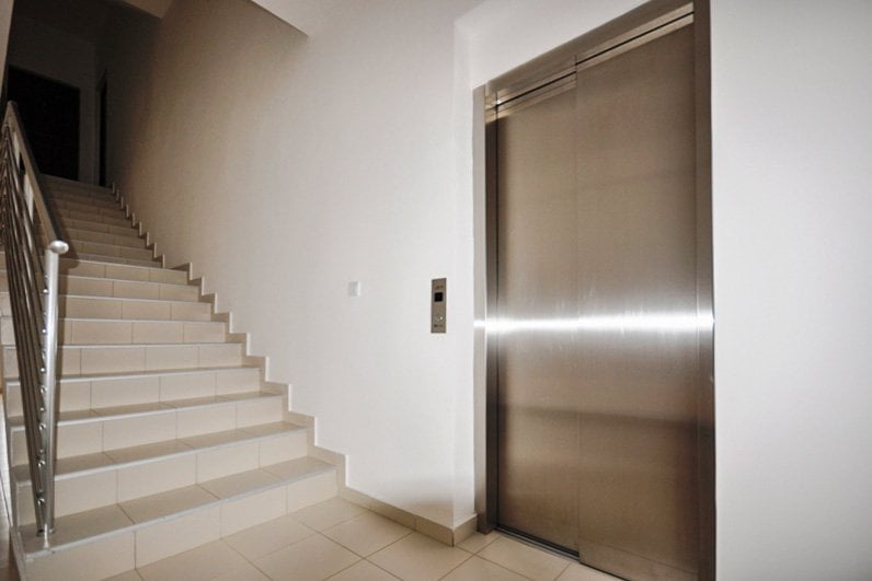 Modern elevator and staircase with handrails in the entrance hall of a residential building in Herceg Novi, Montenegro.
