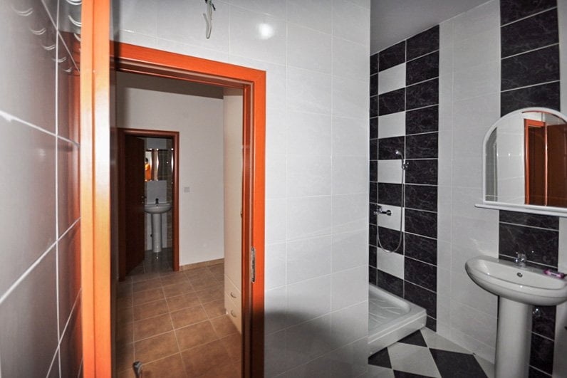 Bathroom with a shower cabin and black-and-white tiles in an apartment in Herceg Novi, Montenegro.