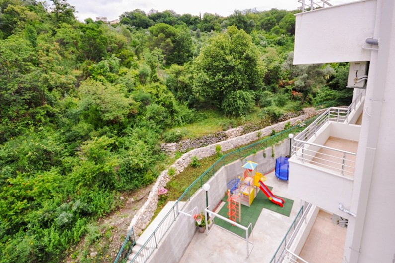 View from the balcony of the playground and the green forest area near the residential complex in Herceg Novi, Montenegro.