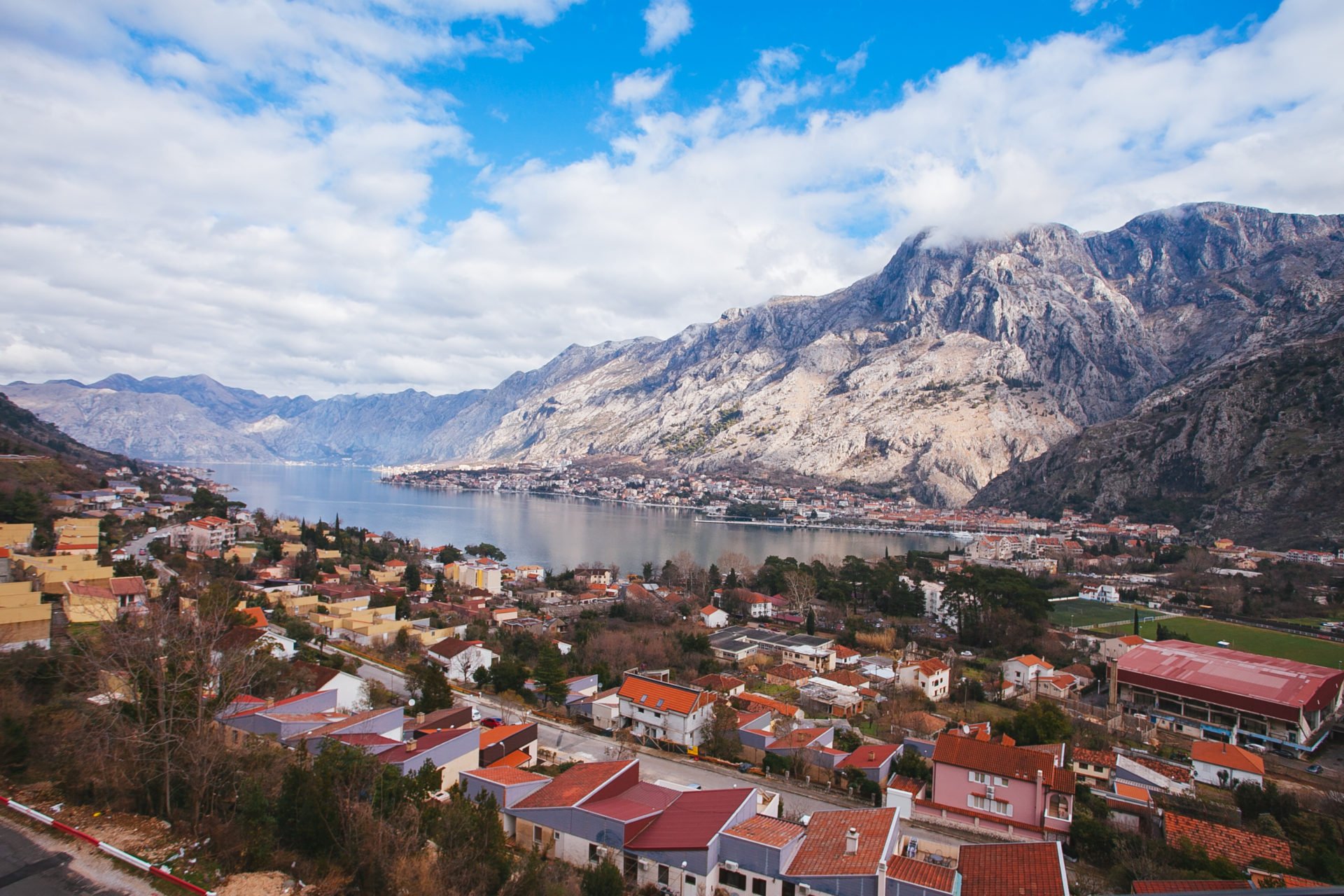 Panoramic view of the Bay of Kotor and the mountains from a residential complex in Kotor, Montenegro: urban development and the sea.