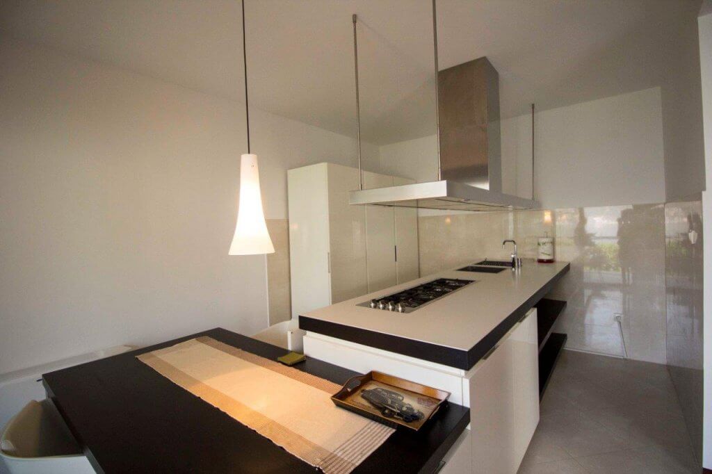 Modern kitchen in an apartment in Stoliv, Montenegro: island with a cooktop, dining area, and stylish finishes.