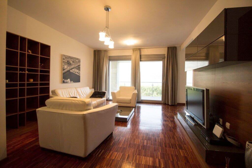Modern living room with white furniture and parquet flooring in an apartment, Stoliv, Bay of Kotor, Montenegro.