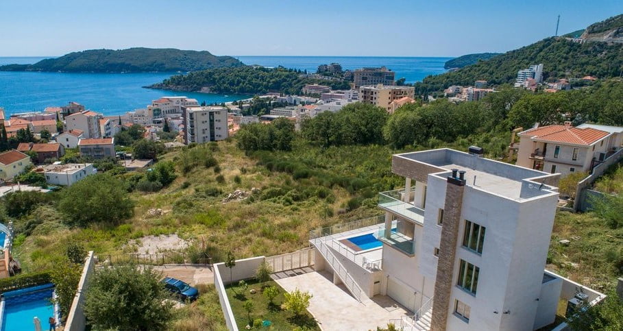 Modern villa with a swimming pool and panoramic views of the sea and the town of Bečići, Montenegro, aerial view.