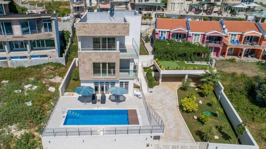 Modern villa with a swimming pool, terrace, and garden in Bečići, Montenegro: aerial view of the private house and grounds.