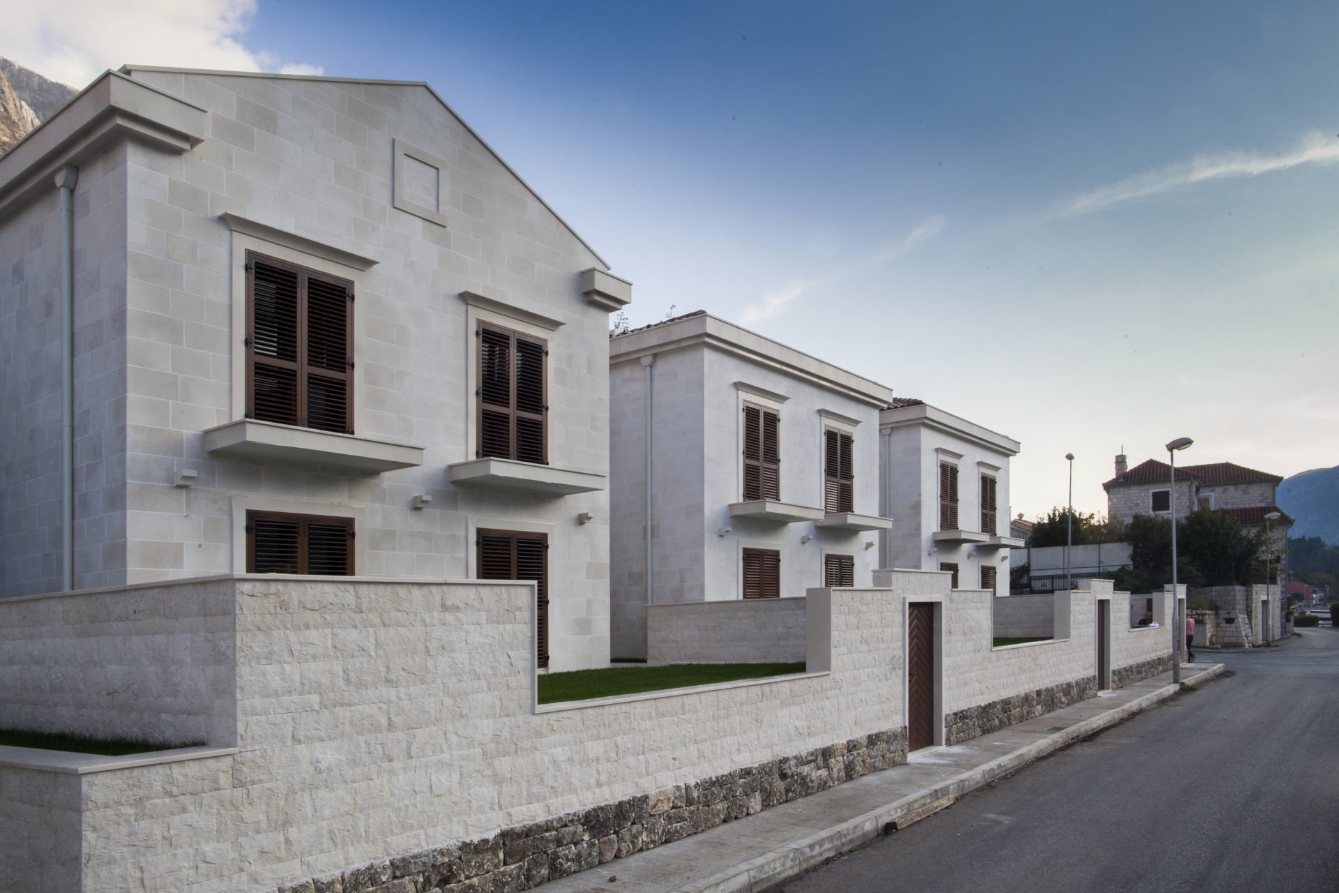 Modern stone villas with brown shutters in a residential complex, Dobrota, Montenegro.