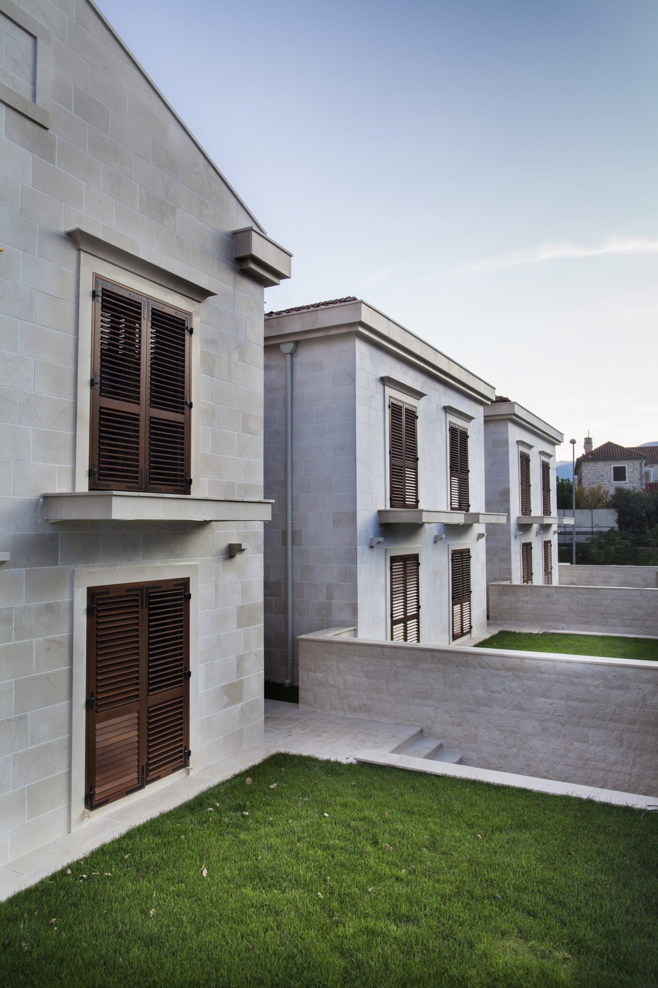 Modern stone villas with wooden shutters and a private garden in a residential complex, Dobrota, Montenegro.