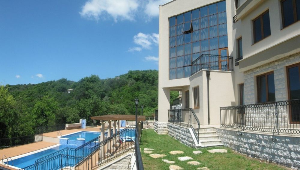 Modern villa with panoramic windows, a swimming pool, and mountain views in Igalo, Montenegro.