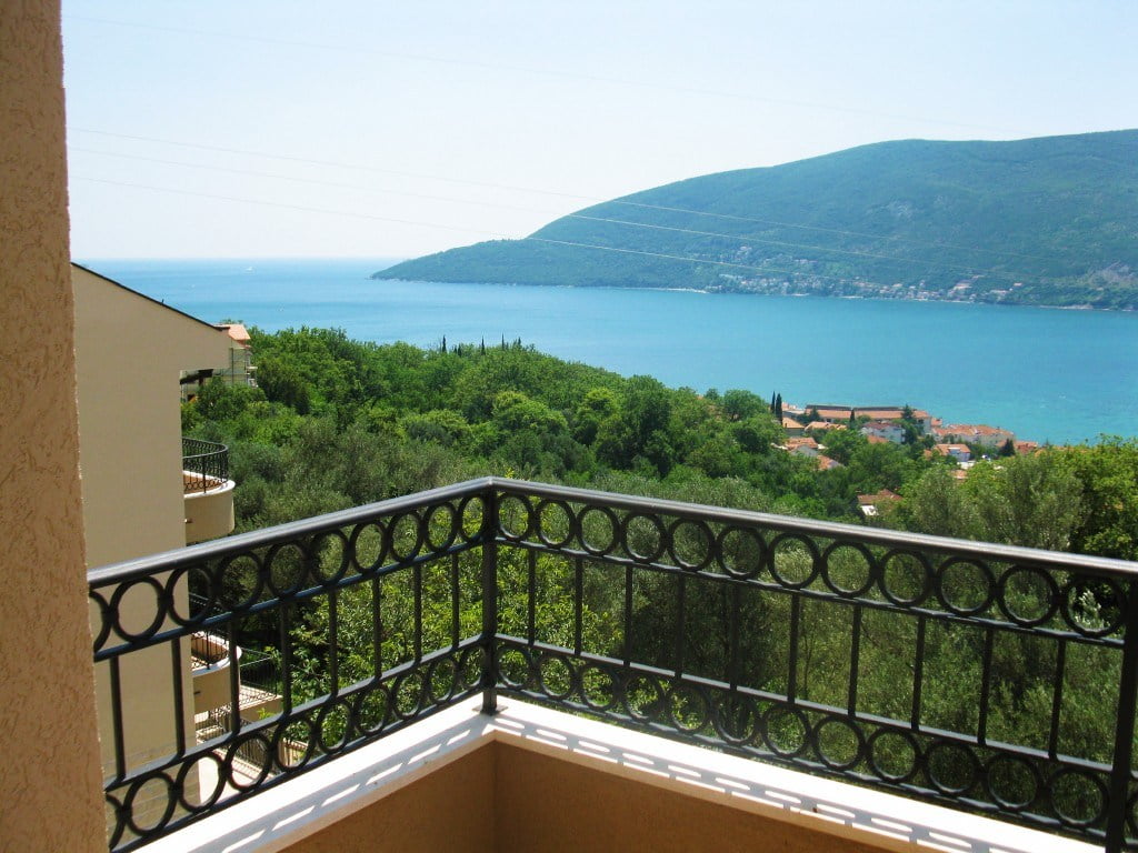 View from the balcony of the sea and mountains in a residential complex, Igalo, Herceg Novi, Montenegro: wrought-iron railing and a panoramic view of the bay.