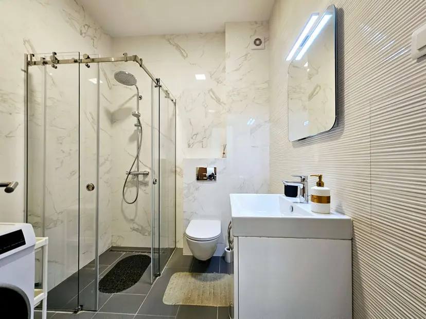 Modern bathroom in an apartment in Budva, Montenegro: shower cabin, plumbing fixtures, and marble-style finishes.