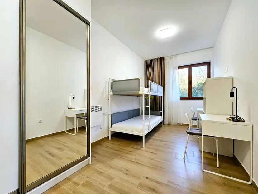 Bedroom with a bunk bed and desks in an apartment, Budva, Montenegro: modern interior with a mirror.