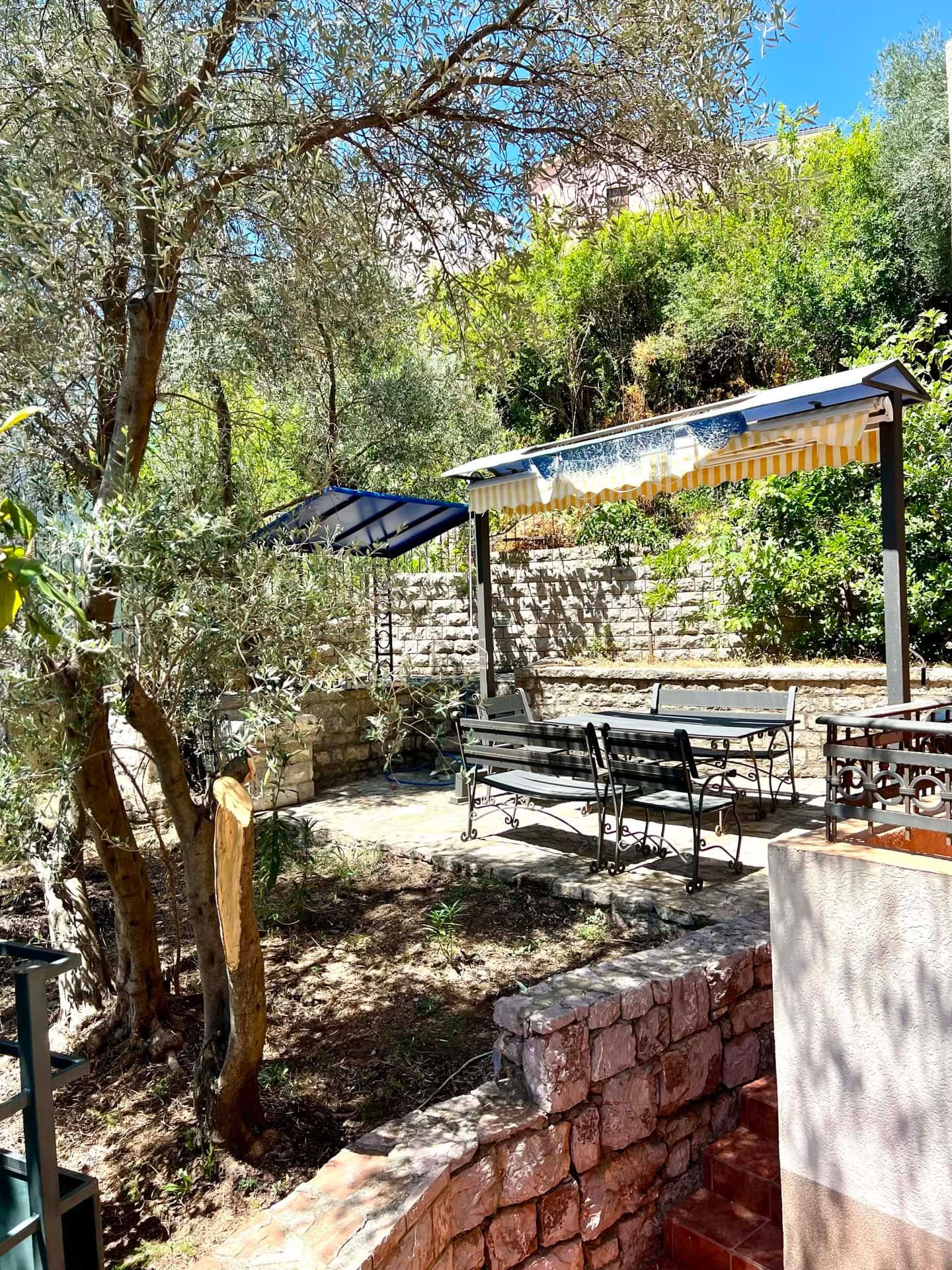 A cozy terrace with garden furniture and an awning in the private garden of an apartment in Petrovac, Montenegro.