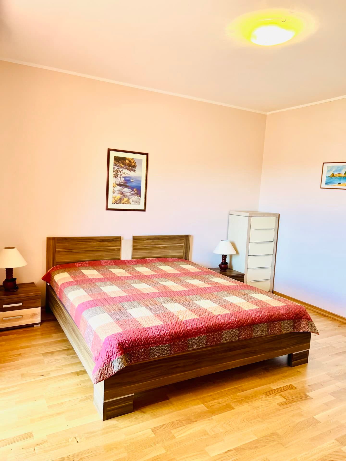 Bright bedroom with a double bed and parquet flooring in an apartment in Petrovac, Montenegro.