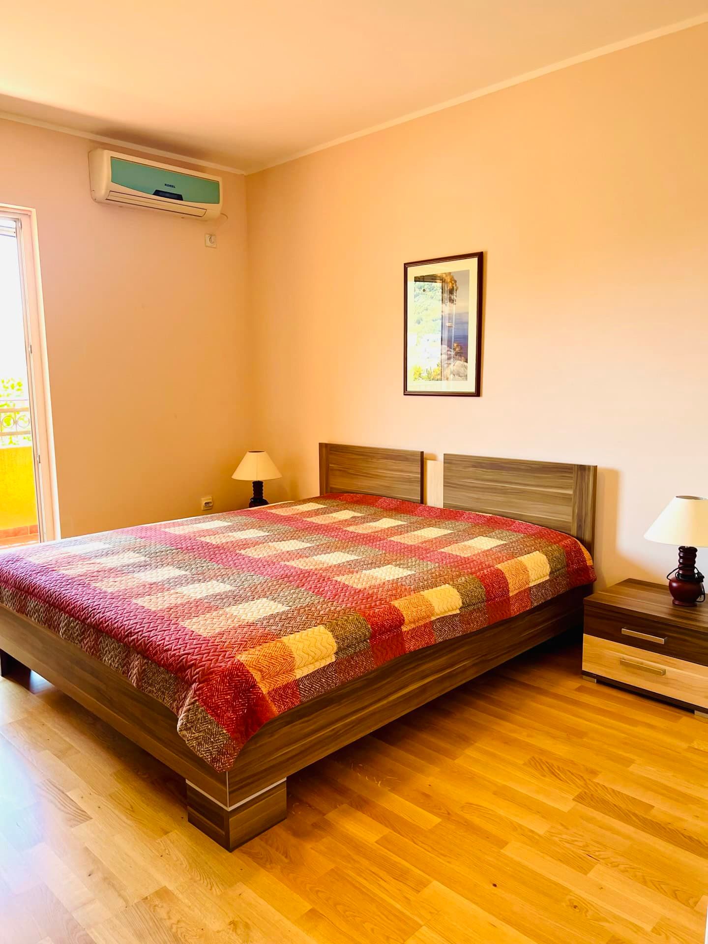 Cozy bedroom with a double bed, parquet flooring, and air conditioning in an apartment in Petrovac, Montenegro.