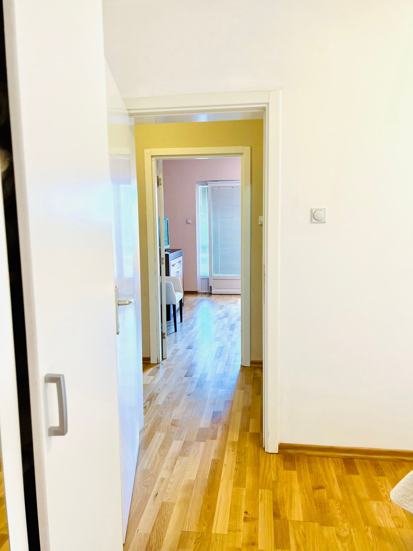 View from the room into a bright living room with parquet flooring and access to the balcony in an apartment, Petrovac, Montenegro.
