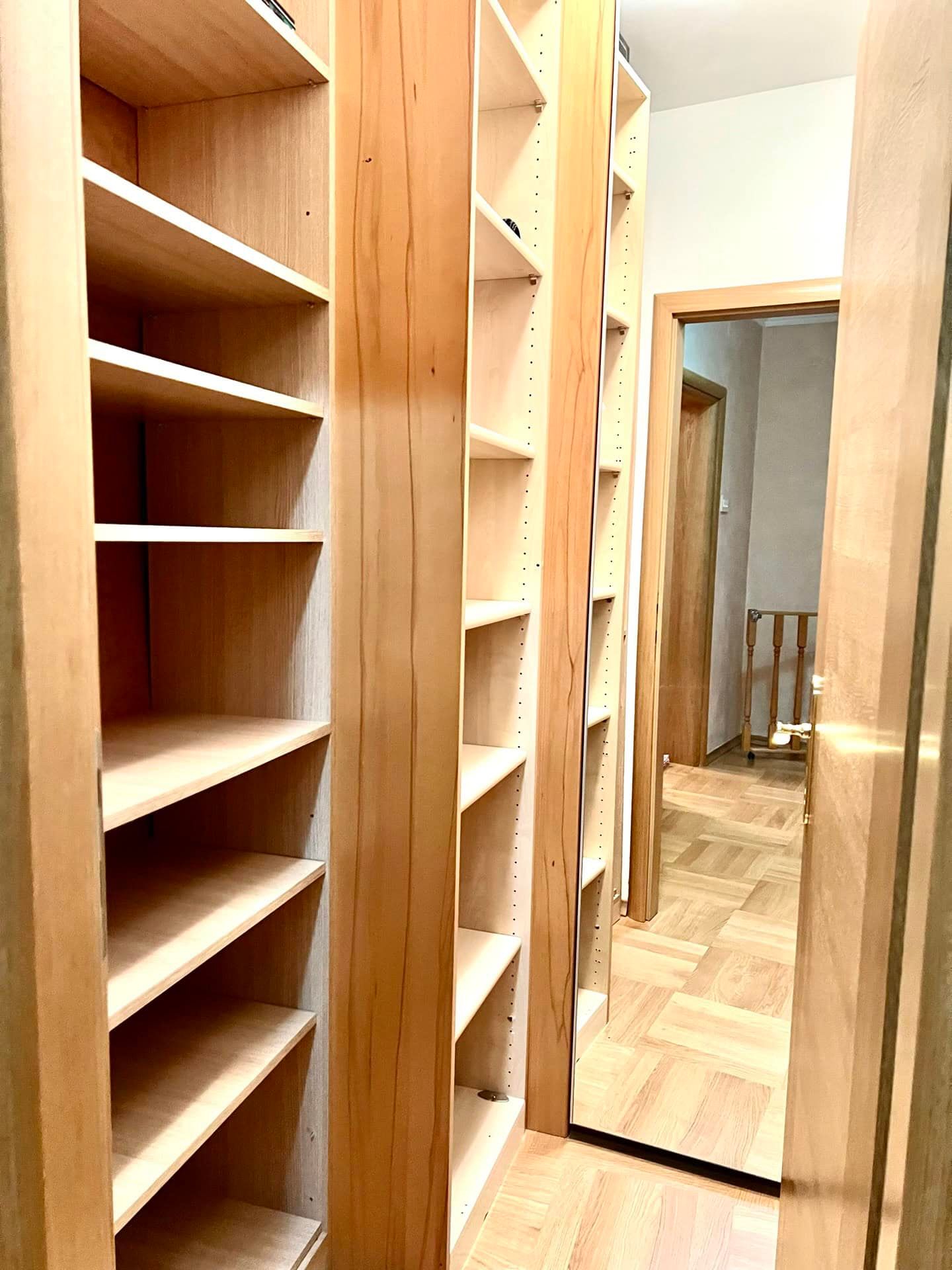 Built-in wooden wardrobe with open shelves and a mirror in the apartment, Petrovac, Montenegro.