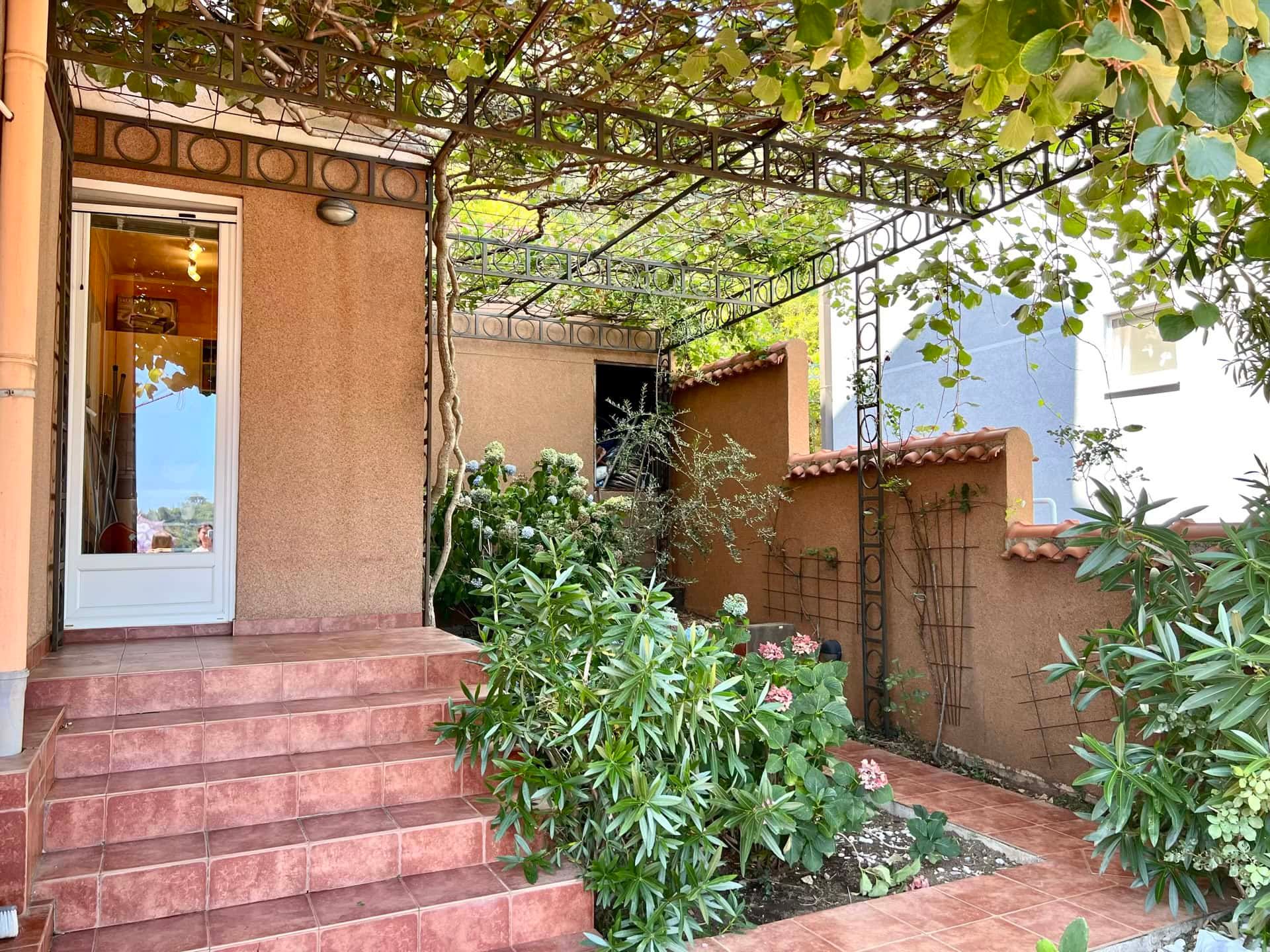 Cozy terrace with a grape pergola and garden by a duplex in Petrovac, Montenegro.