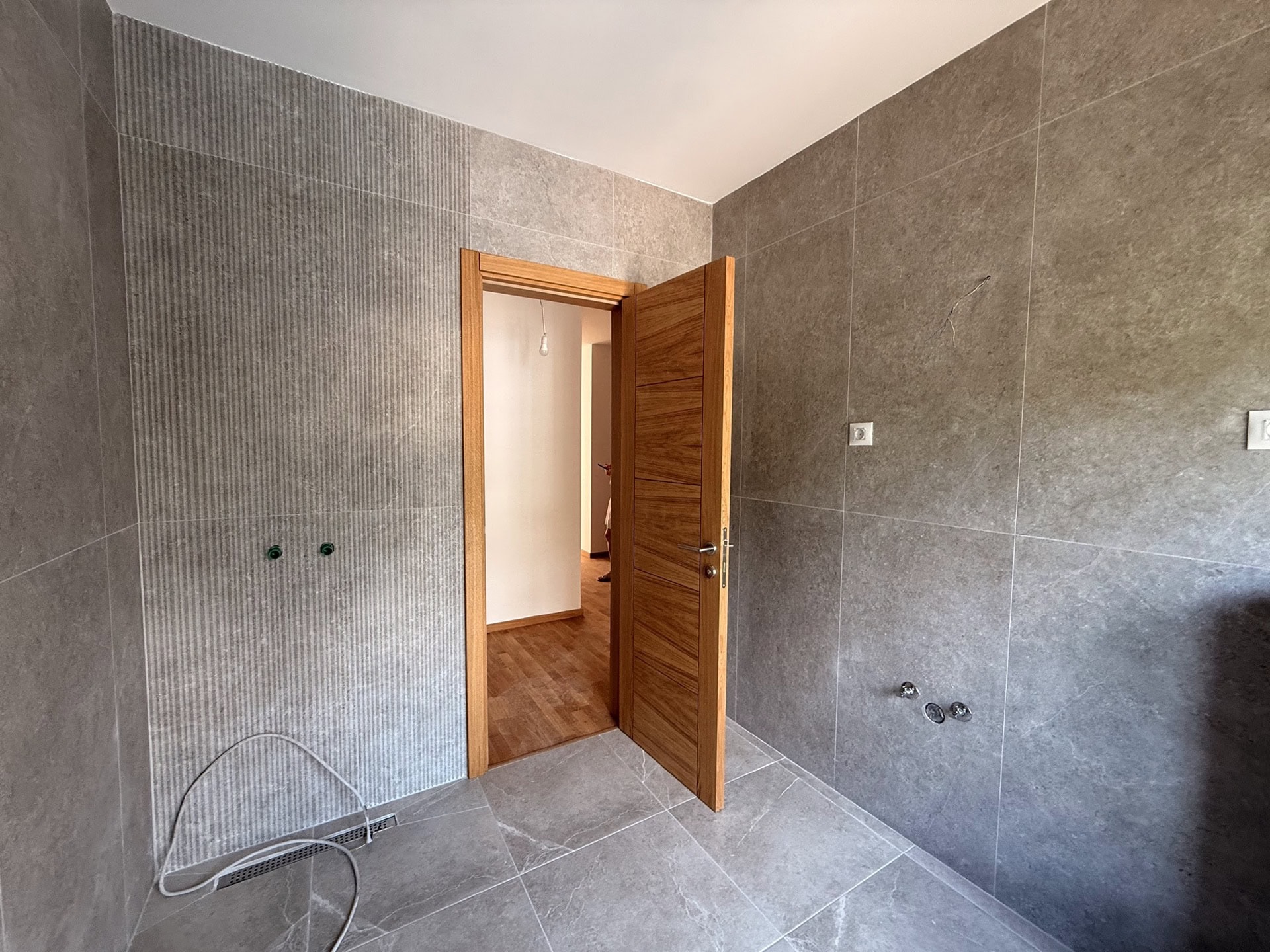 Modern bathroom with gray tile finishes in a new apartment in Bečići, Montenegro.