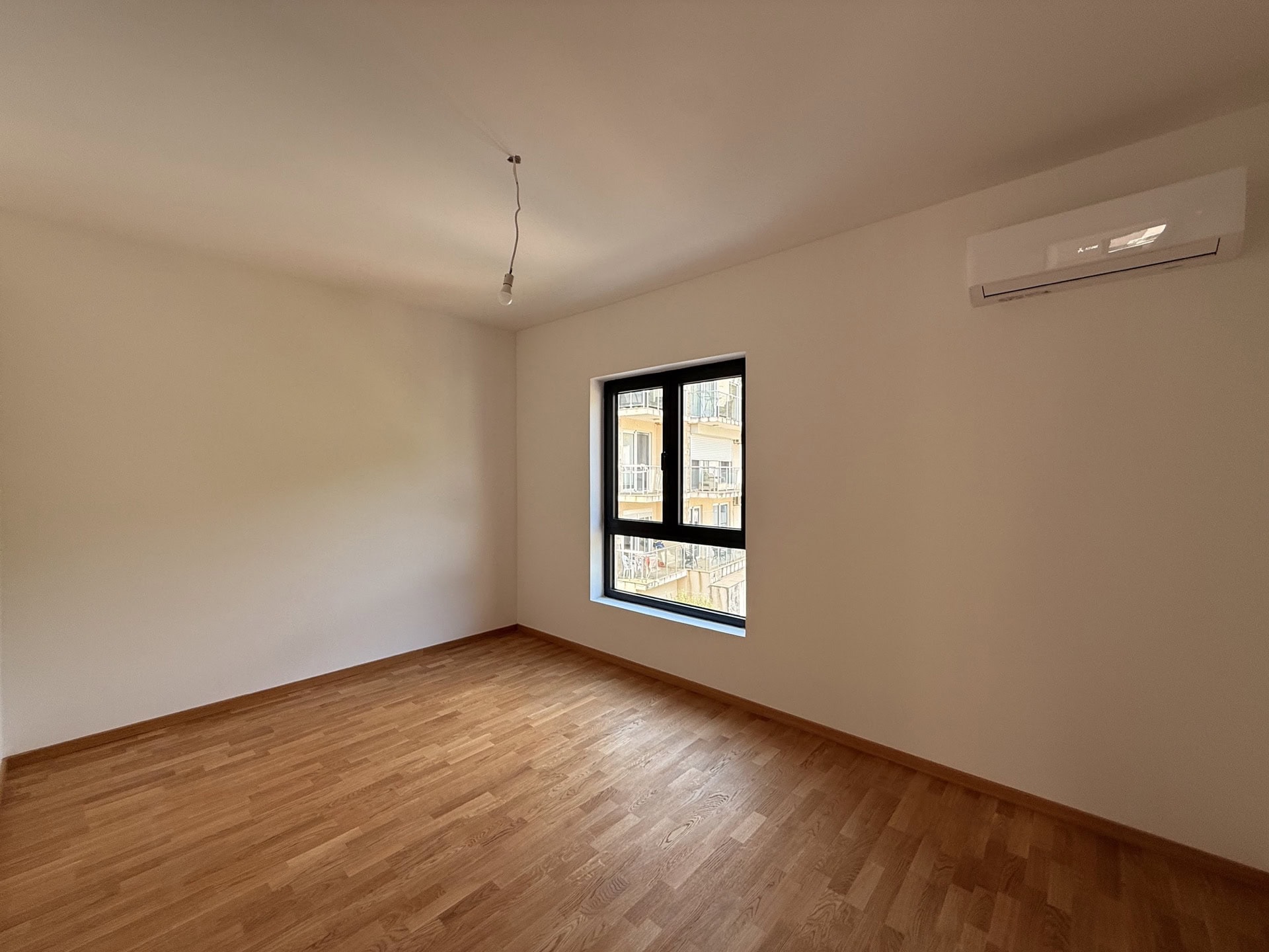 Bright bedroom with parquet flooring and air conditioning in an apartment for sale in Bečići, Montenegro.