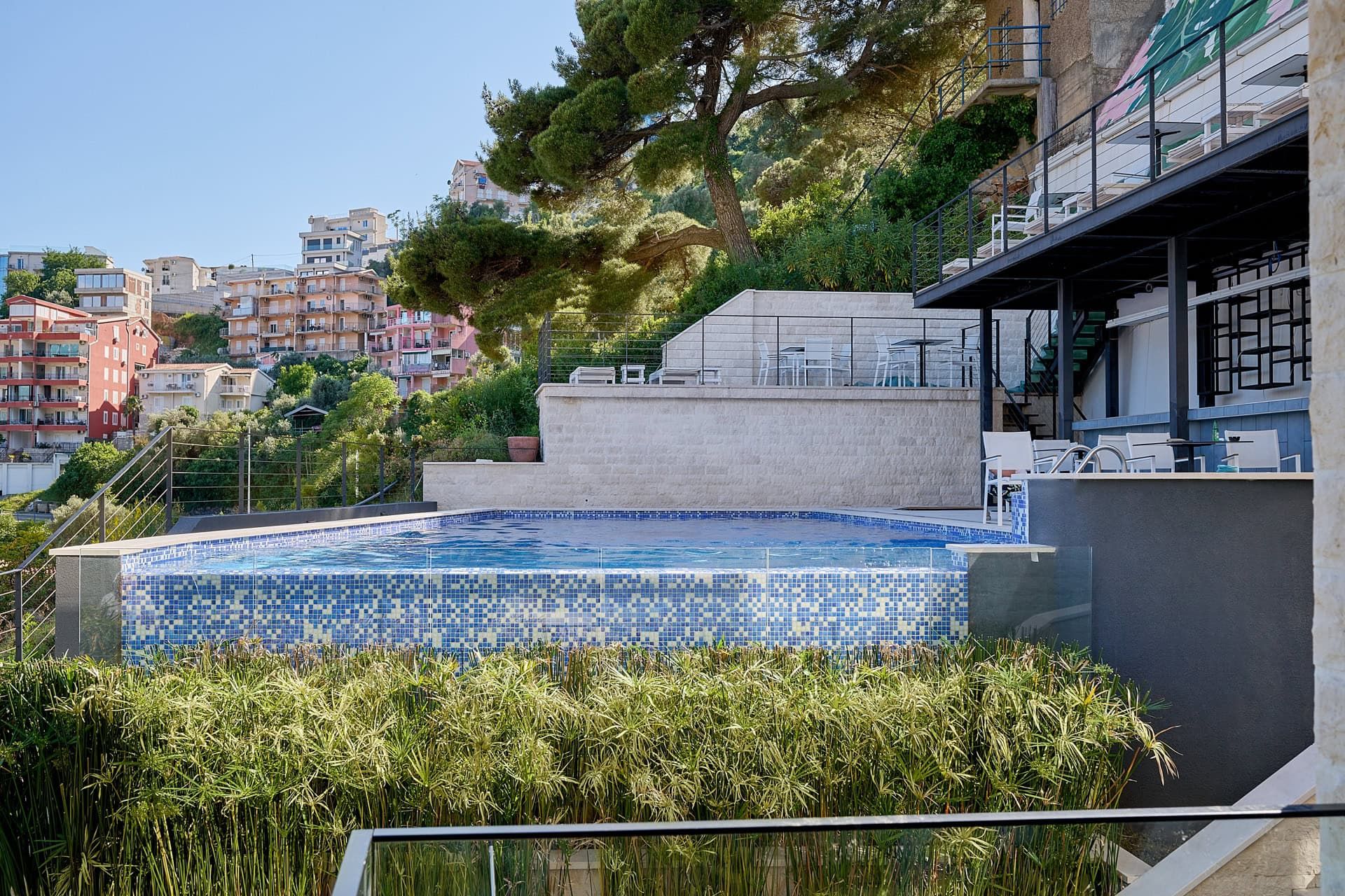 Outdoor pool with mosaic finish and terrace in a residential complex, Budva, Montenegro. City and mountain view.