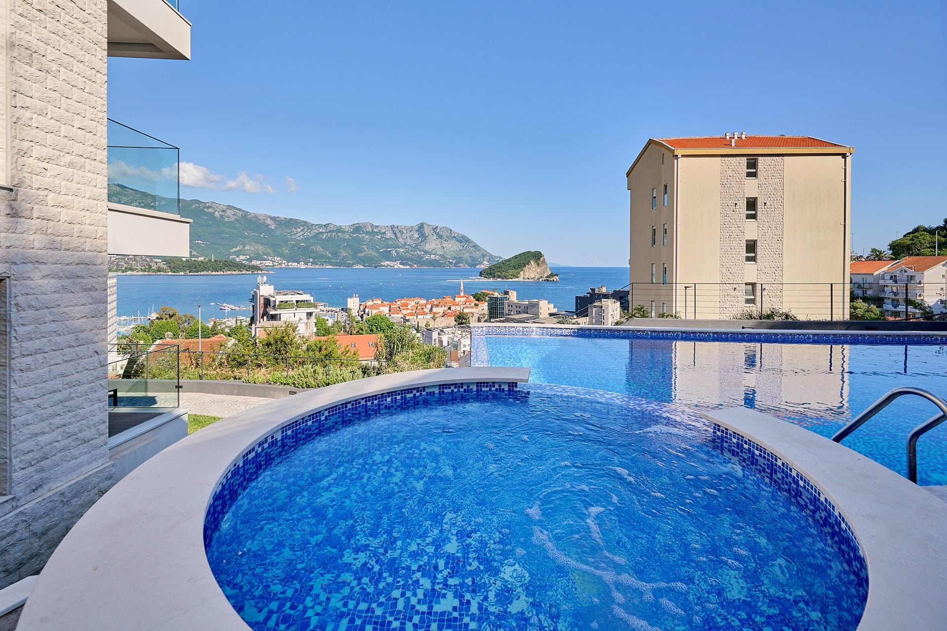 Outdoor pool with panoramic views of the sea, St. Nicholas Island, and the city of Budva, Montenegro.