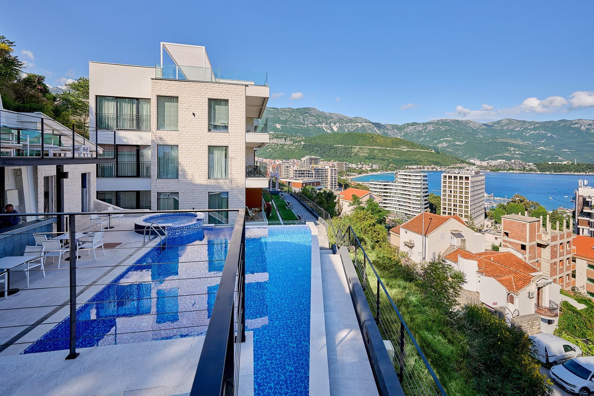 Modern residential complex with a panoramic pool and views of the sea and mountains in Budva, Montenegro.