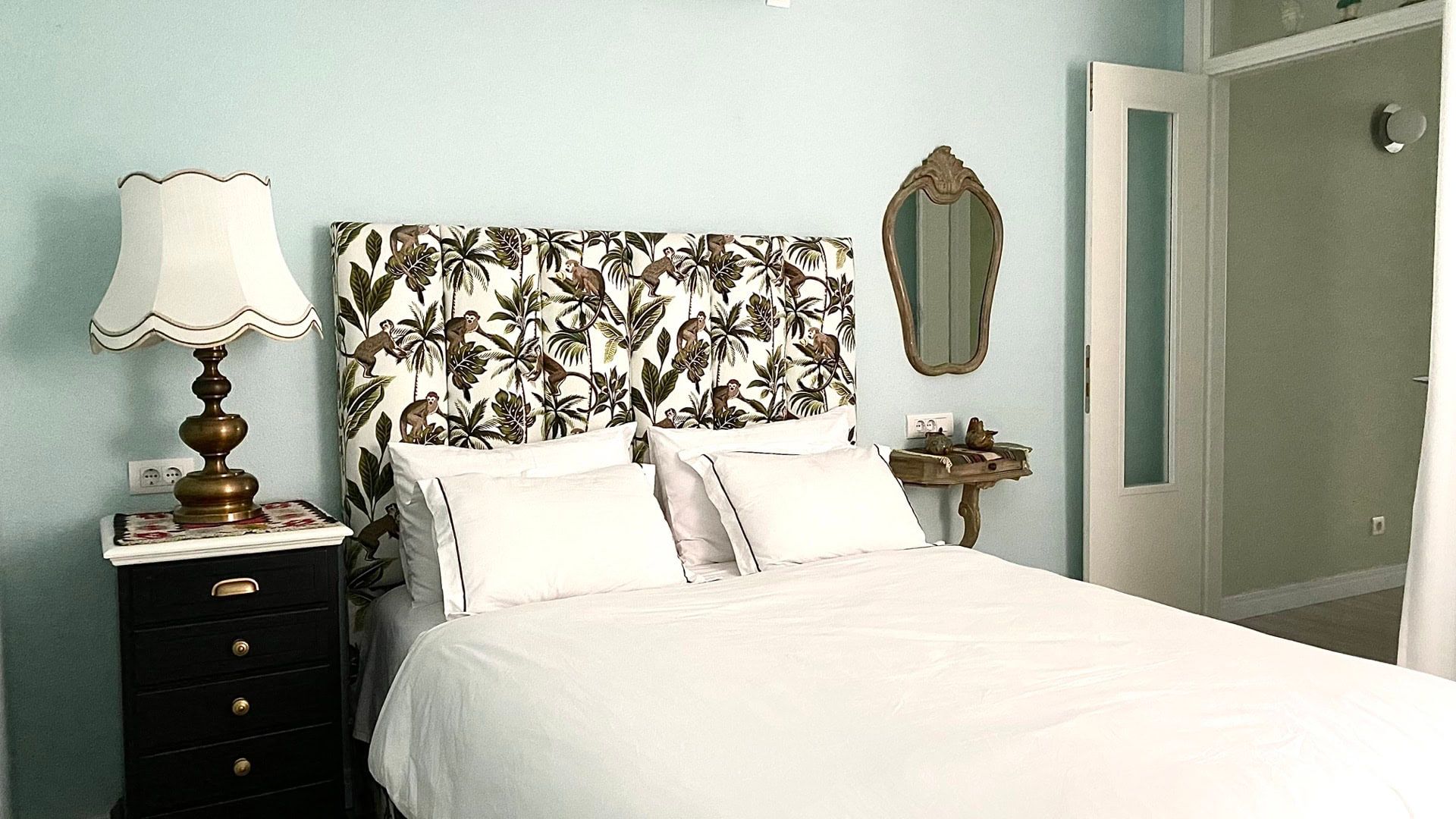 Cozy bedroom in an apartment in Petrovac, Montenegro: a double bed with a printed headboard and vintage decor.