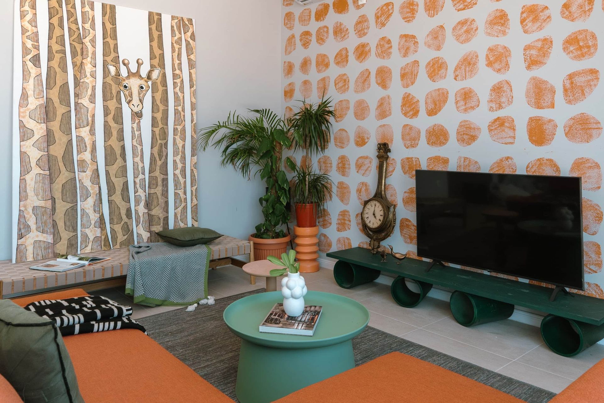 Living room interior in a villa in Krašići, Montenegro: designer furniture, vibrant wallpaper, and a giraffe painting.