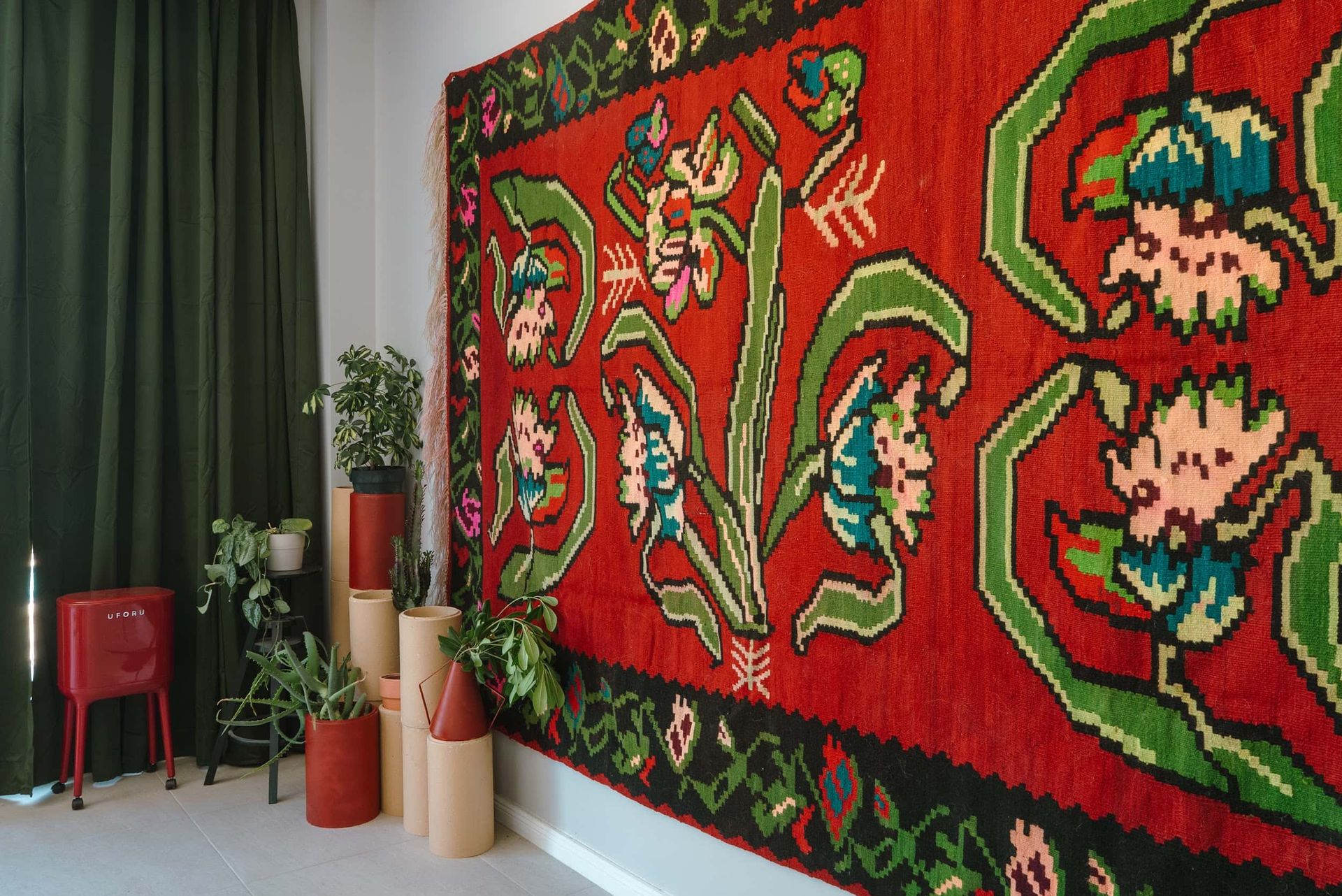 Interior of a villa living room in Krašići, Montenegro: bright traditional rug on the wall, houseplants, and decor.