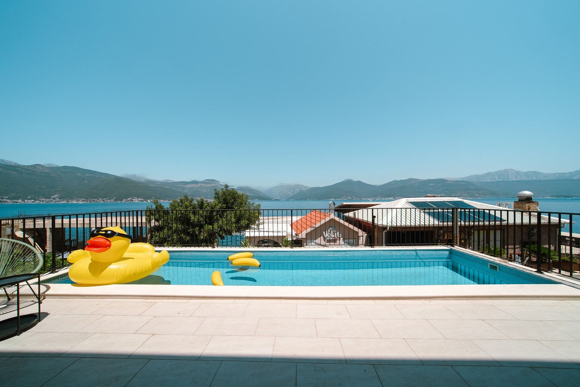 Outdoor swimming pool on a villa terrace in Krašići, Montenegro, with a panoramic view of the sea and the mountains of the Bay of Kotor.