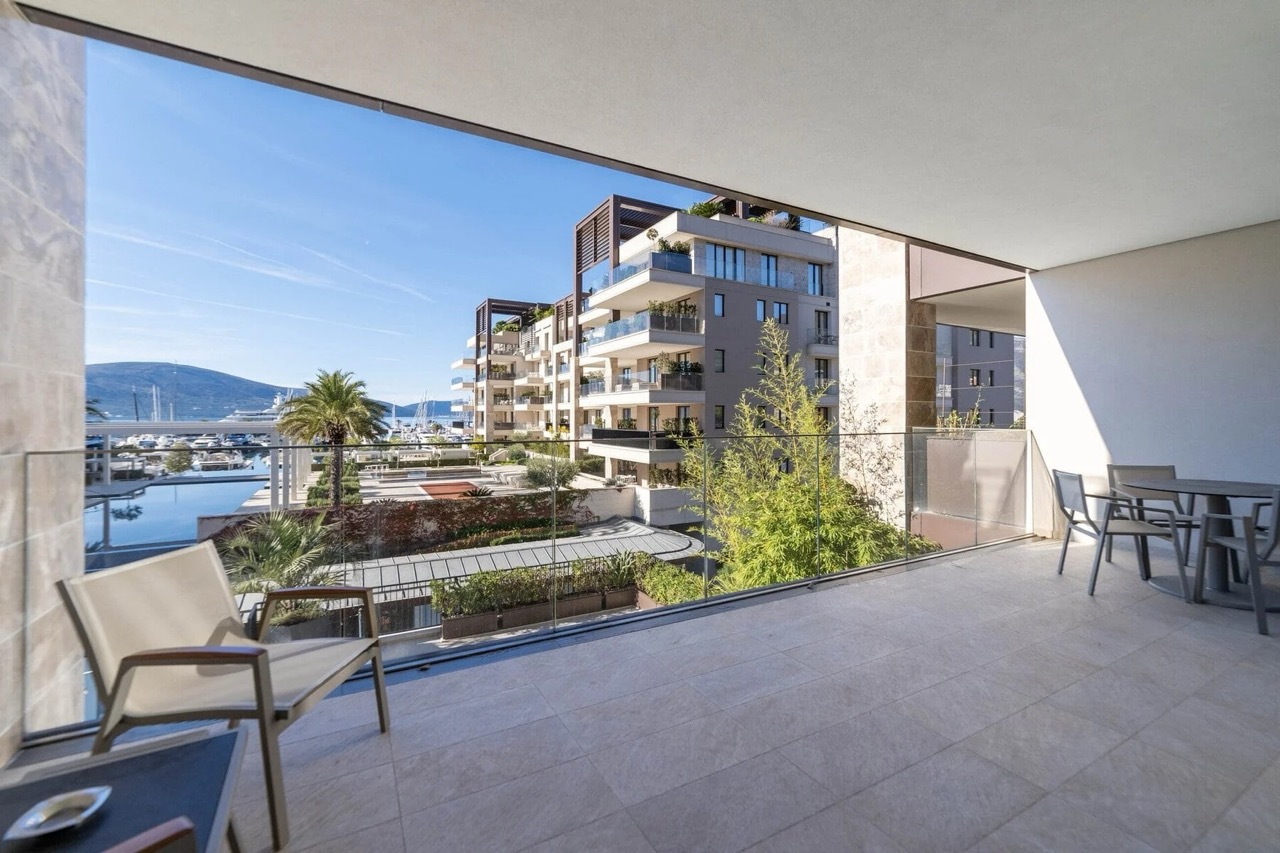 Spacious balcony with furniture and views of the marina and yachts in the prestigious Porto Montenegro complex, Tivat, Montenegro.