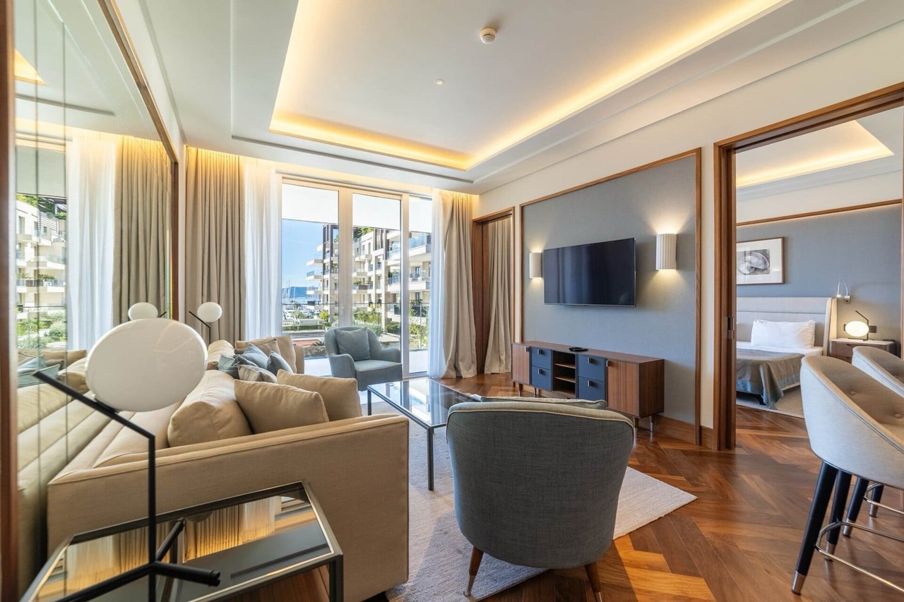 Modern living room in Porto Montenegro apartments, Tivat, Montenegro: stylish furniture, parquet flooring, and a view of the marina.