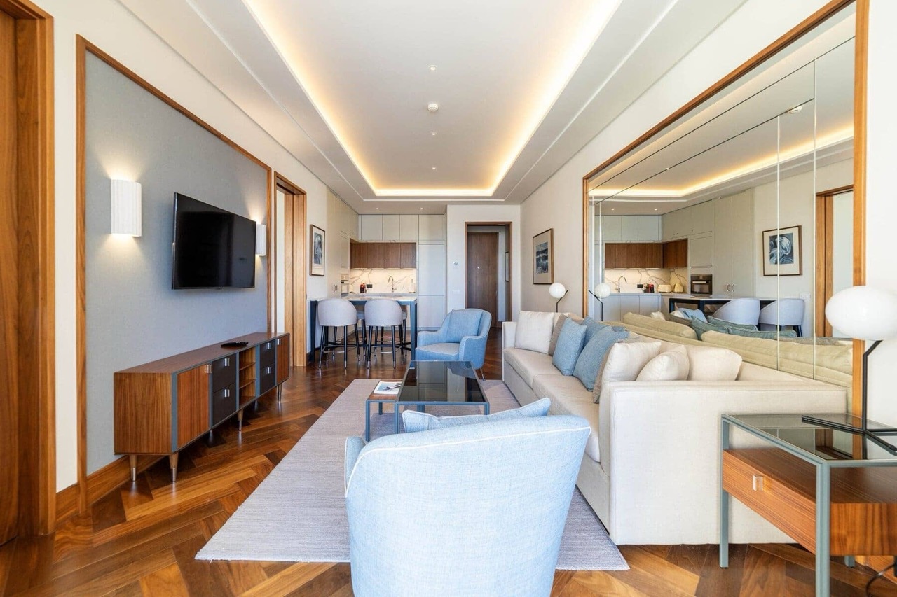 Modern living room with kitchen in an apartment, Porto Montenegro, Tivat, Montenegro: parquet flooring, light furniture and decor.