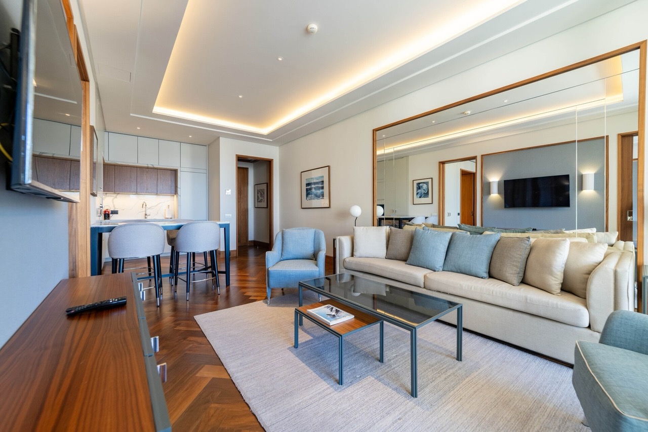 Modern living room with kitchen in an apartment in Porto Montenegro, Tivat, Montenegro: stylish furniture, parquet flooring, and decor.