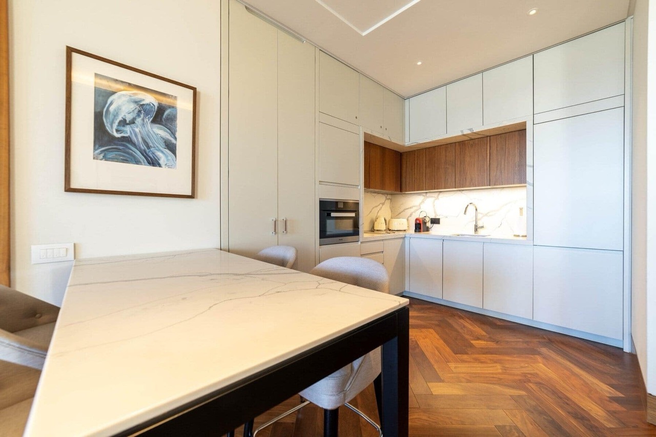 Modern kitchen with a marble countertop and parquet flooring in an apartment in Porto Montenegro, Tivat, Montenegro