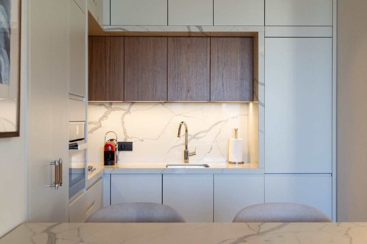 Modern kitchen with a marble backsplash and wooden cabinets in an apartment in Porto Montenegro, Tivat, Montenegro.