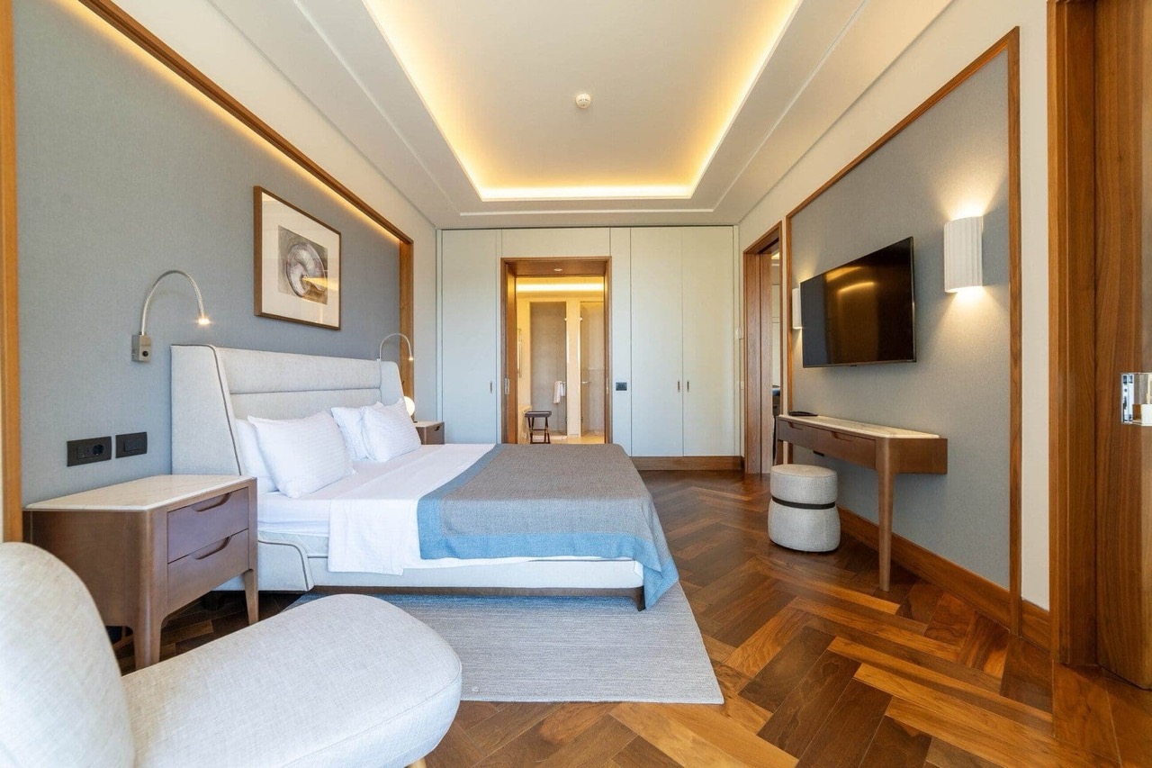 Modern bedroom in an apartment in Porto Montenegro, Tivat, Montenegro: double bed, parquet flooring, and designer lighting.
