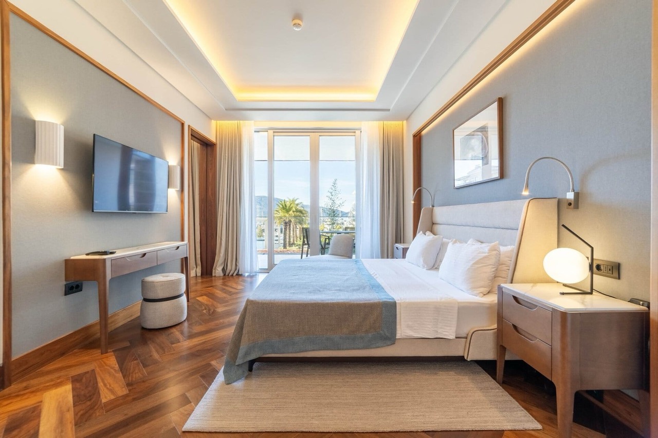 Modern bedroom in an apartment in Porto Montenegro, Tivat, Montenegro: double bed, parquet flooring, and a view of the marina.