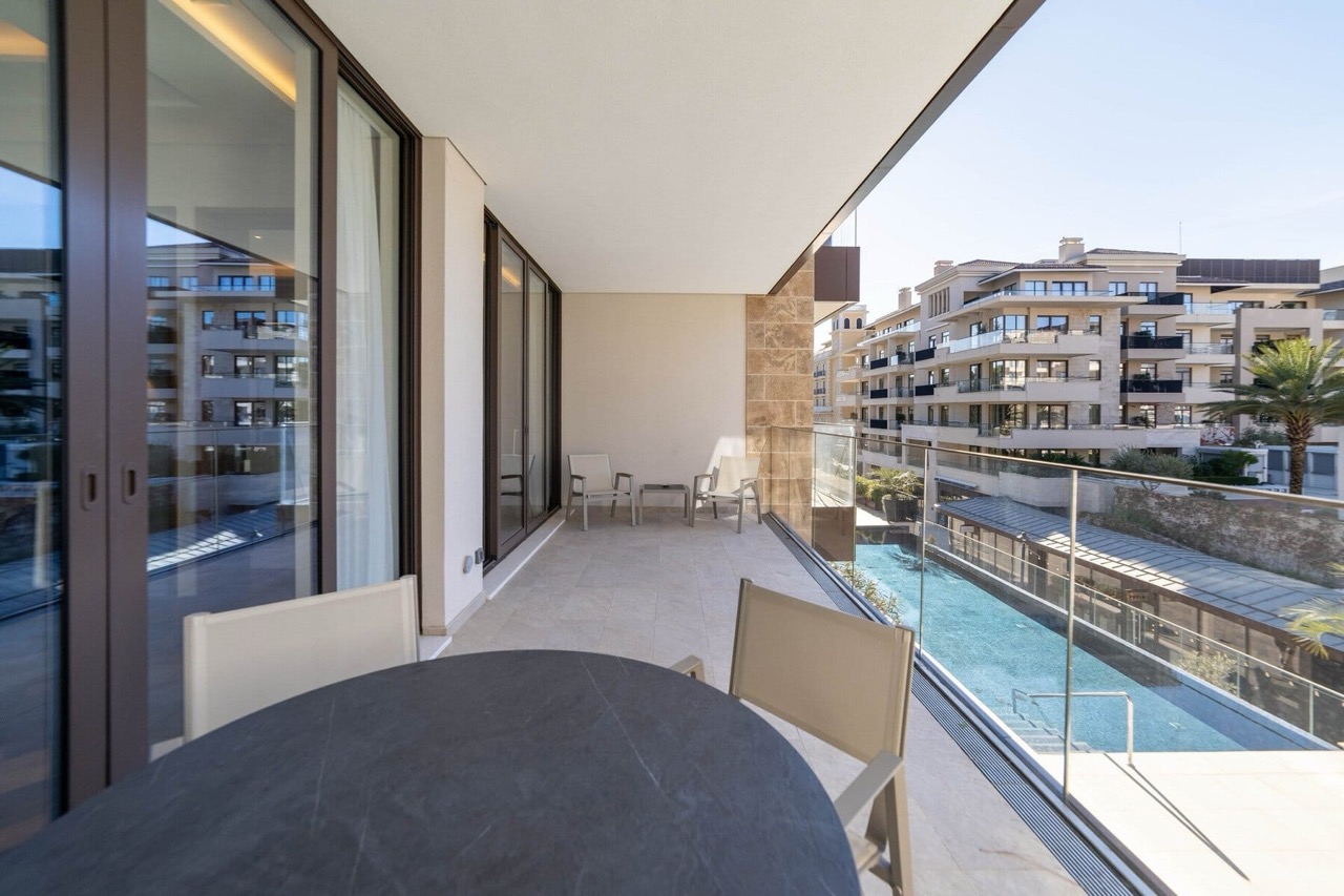 Spacious balcony with furniture and a view of the pool in the luxury Porto Montenegro residential complex, Tivat, Montenegro.