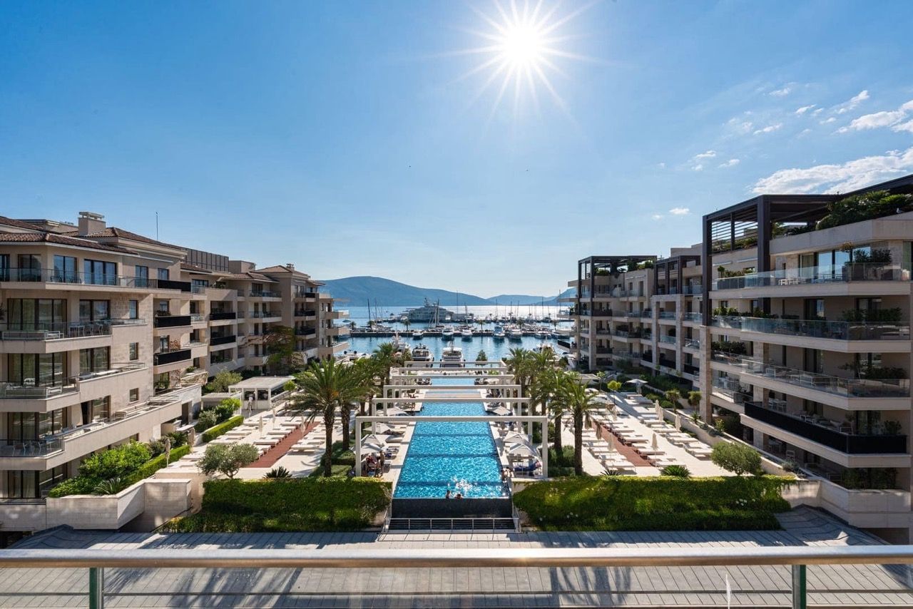 View of the pool and Porto Montenegro yacht marina in Tivat, Montenegro, from a luxury residential complex with terraces.