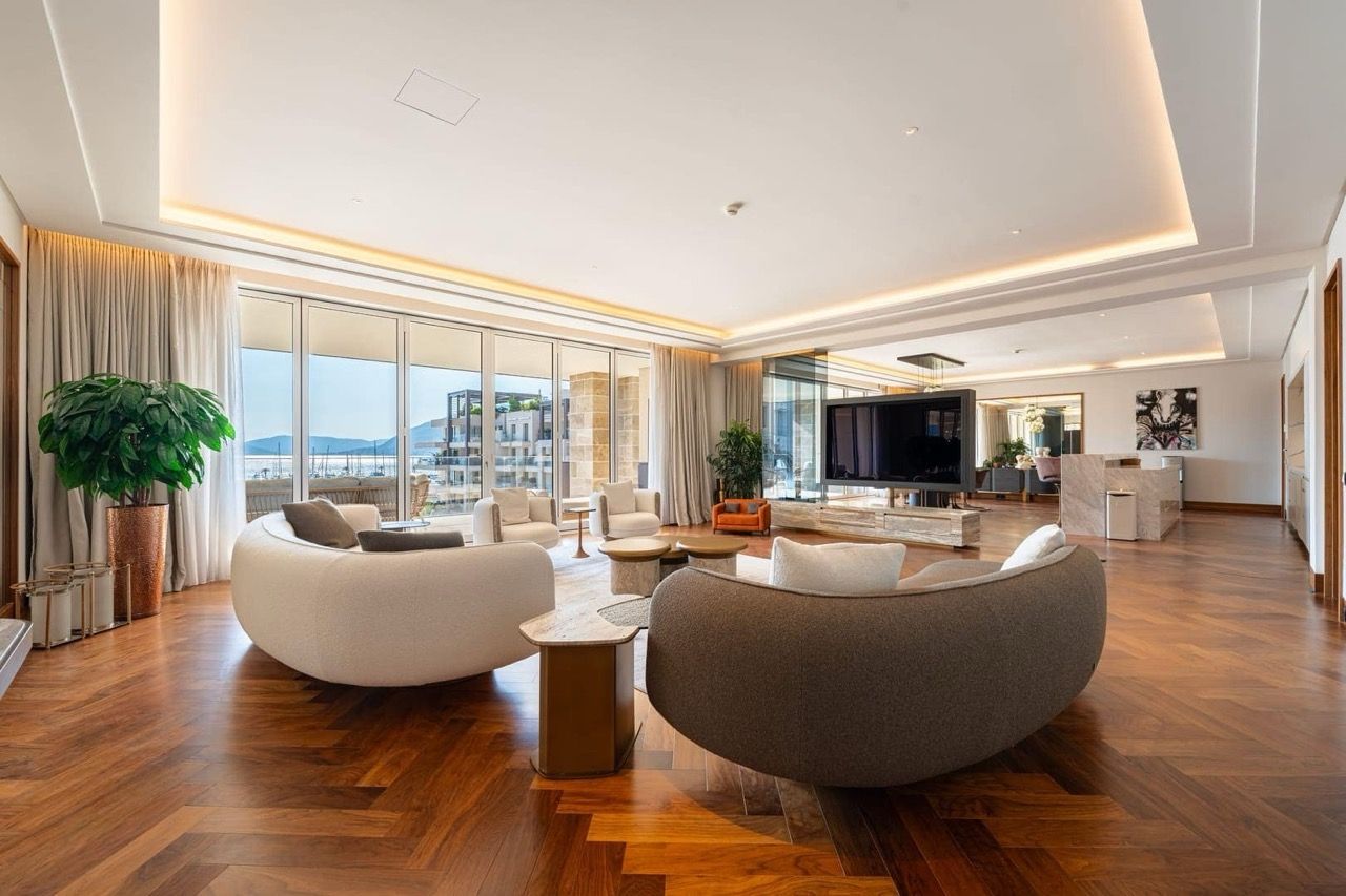 Spacious living room in a luxury apartment in Porto Montenegro, Tivat, Montenegro, with a view of the marina and parquet flooring.