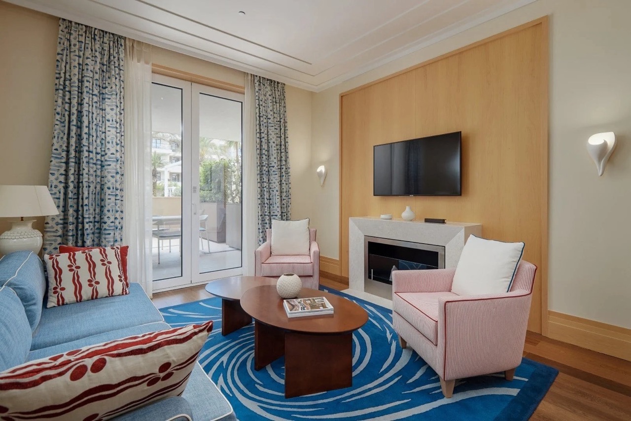 Living room with a fireplace and terrace in Porto Montenegro apartments, Tivat, Montenegro: modern interior with furniture.